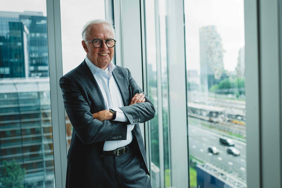 Nieuwe penningmeester van de VUvereniging Jan van der Hilst staand bij het raam van een kantoorgebouw op de Zuidas