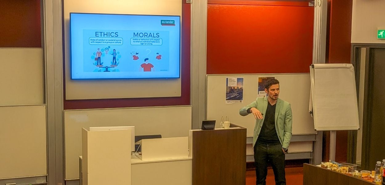 A man standing in front of a screen with inscriptions "morals" and "ethics"