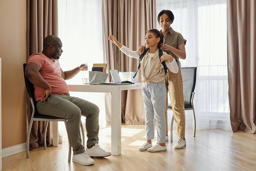 Ouders zorgen dat hun dochter er goed uit ziet om naar school te gaan.