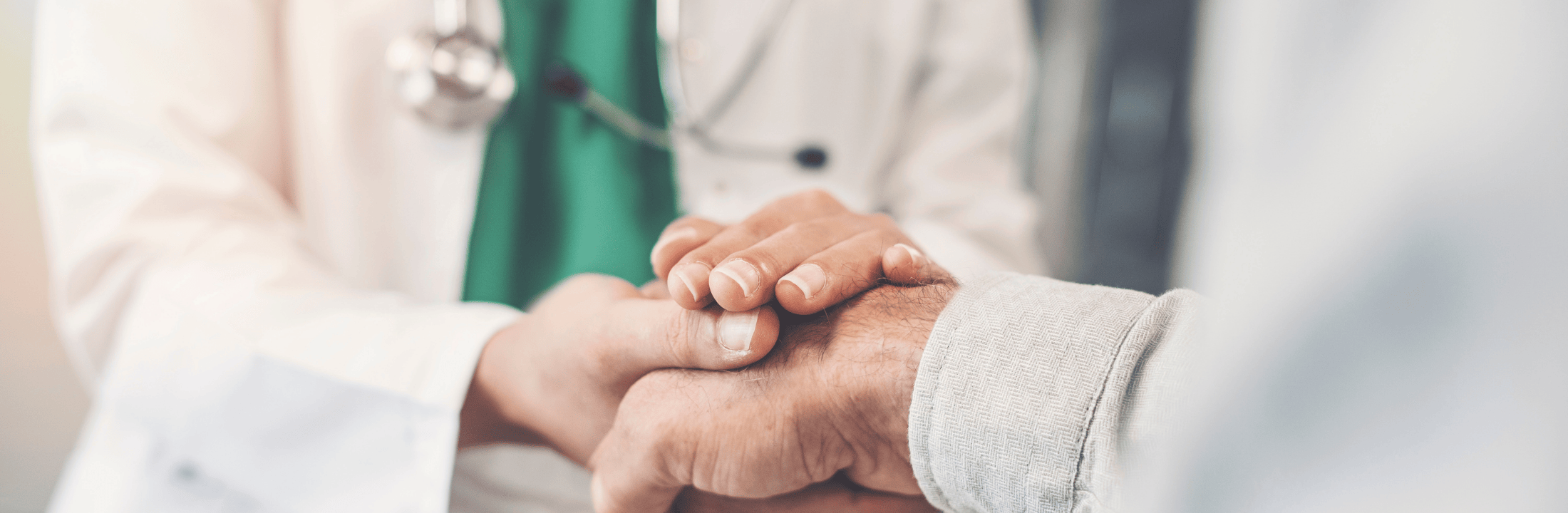 Clasped hands of a doctor and patient