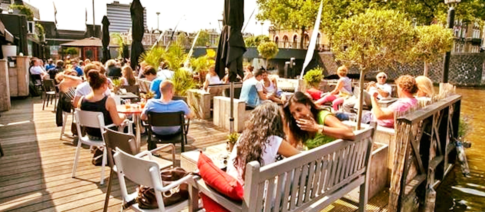 People sitting on a terrace by the water