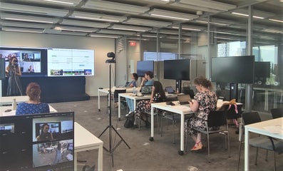 A lecturer during a hybrid session with online students and 4 live students