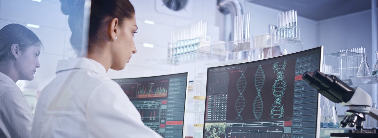 Laboratory assistants looking at a computerscreen with DNA molecules