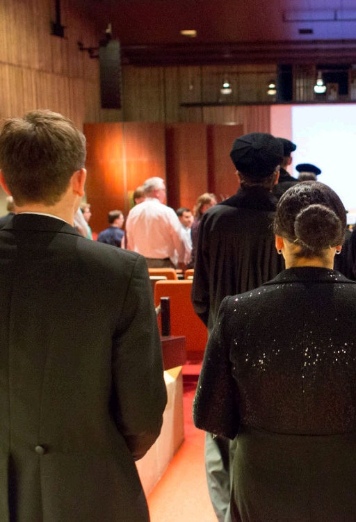 Standing people in a room at the start of a doctoral ceremony