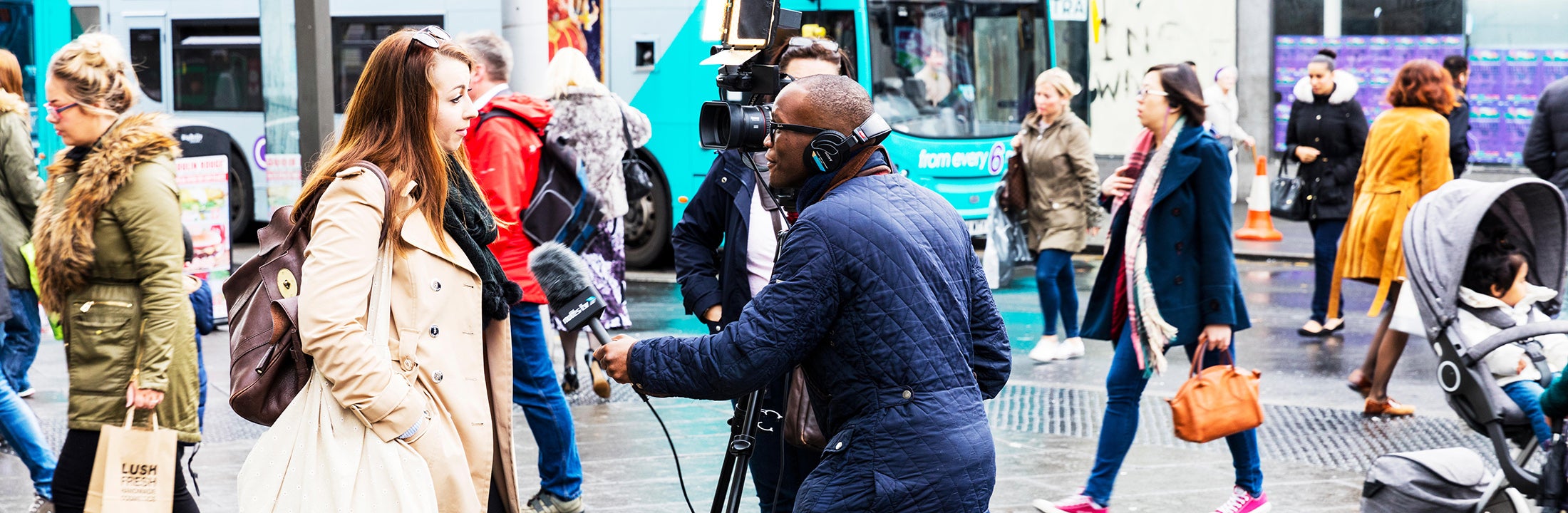 Een man met koptelefoon en microfoon interviewt een vrouw