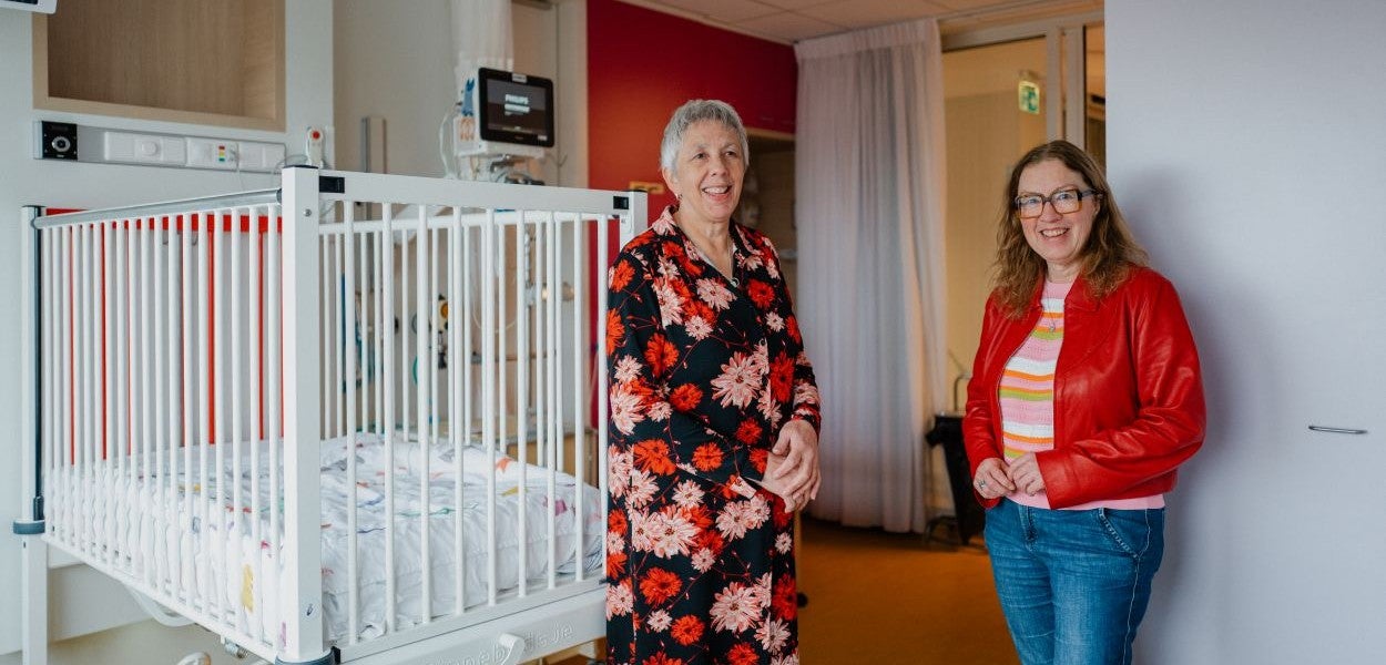 Anja Portengen en Benita Spronk voor een ziekenhuisbed.