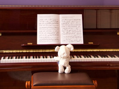 The photo shows a stuffed animal playing the piano. Photo by Paolo Chiabrando on Unsplash.