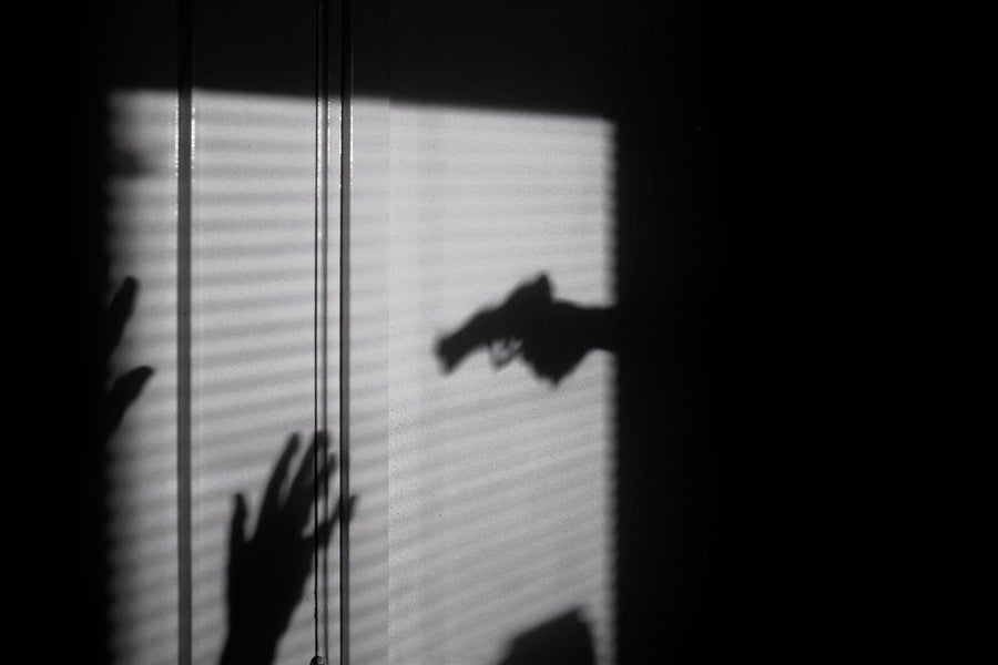 A shadow of someone with a gun