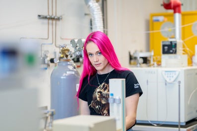 A woman with pink hair in a lab