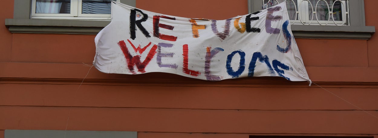 Een spandoek met de tekst 'Vluchtelingen welkom' in het Engels 