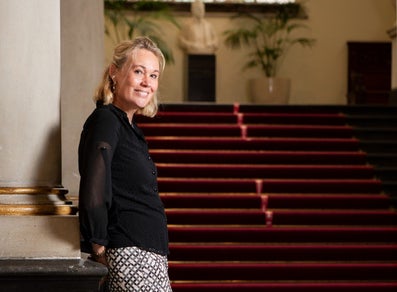 A woman leans against a pillar