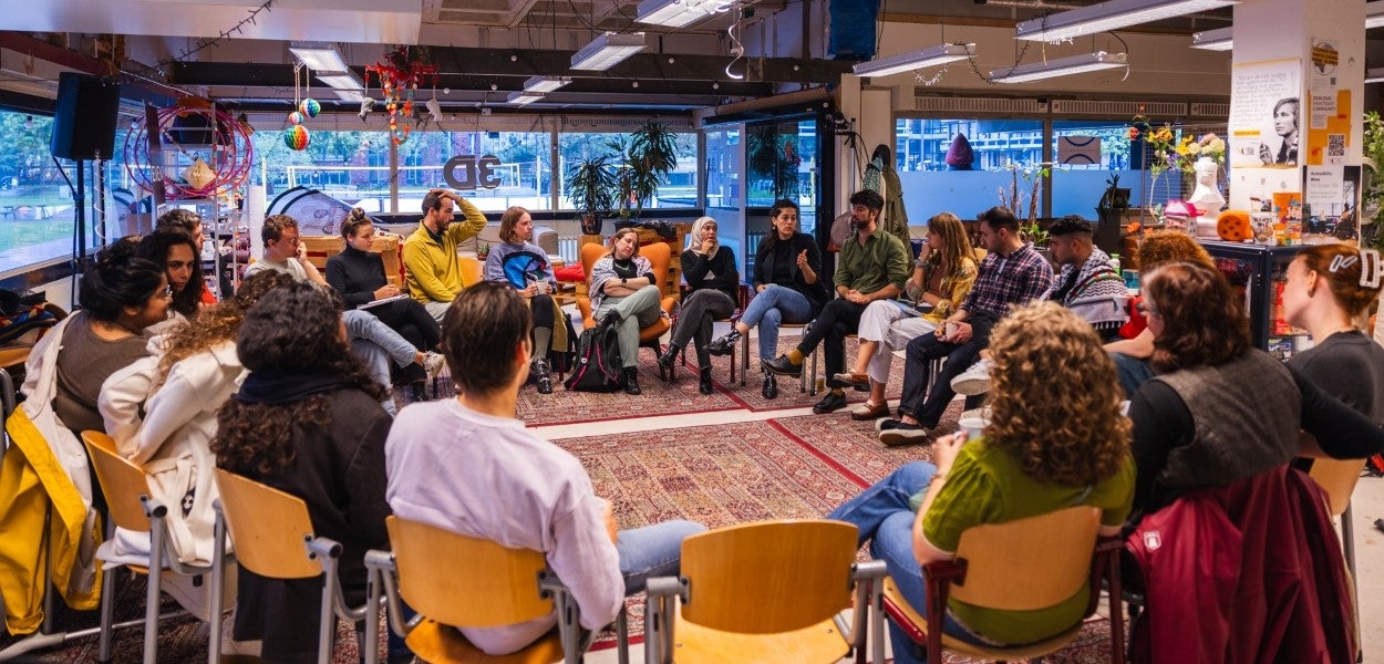A group of people sit in a circle in the space where 3D organises its activities.