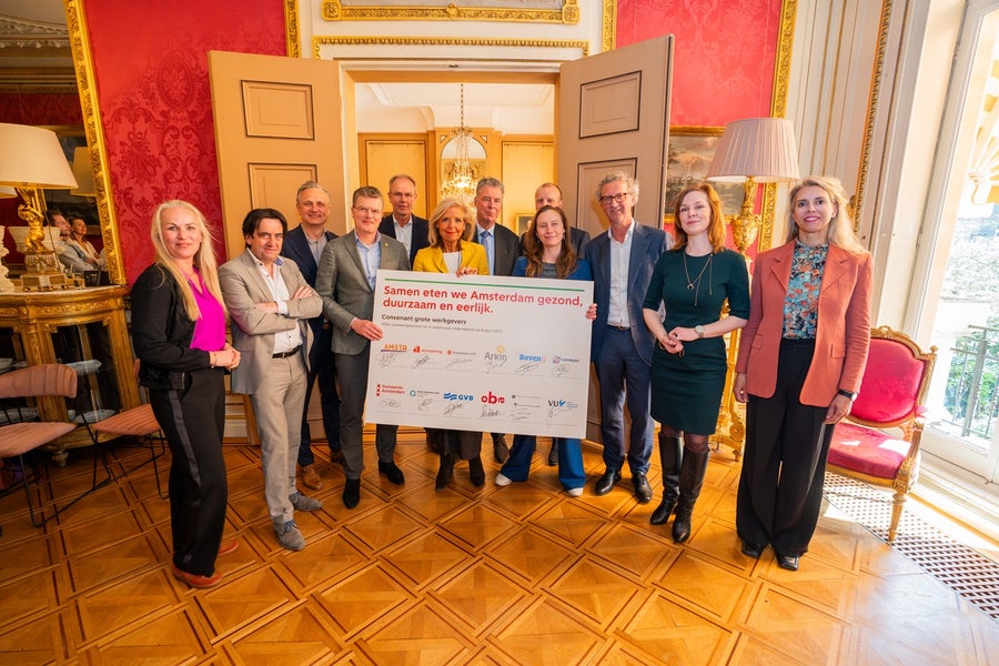 directeuren van grote Amsterdamse bedrijven staan bij het ondertekende contract voor duurzaam eten