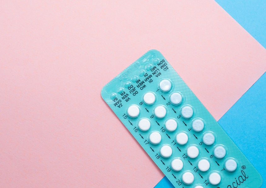 A pack of pills on a blue and pink background