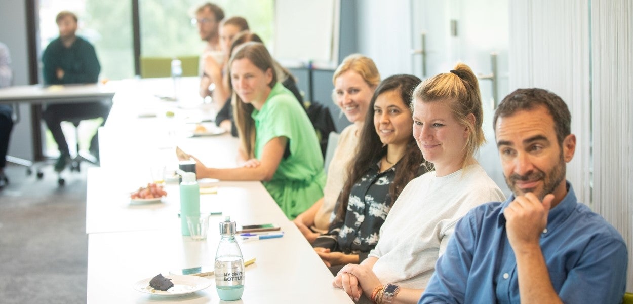 Group of people sitting at a table and listening.