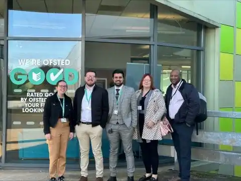  A group of colleagues stand outside a college