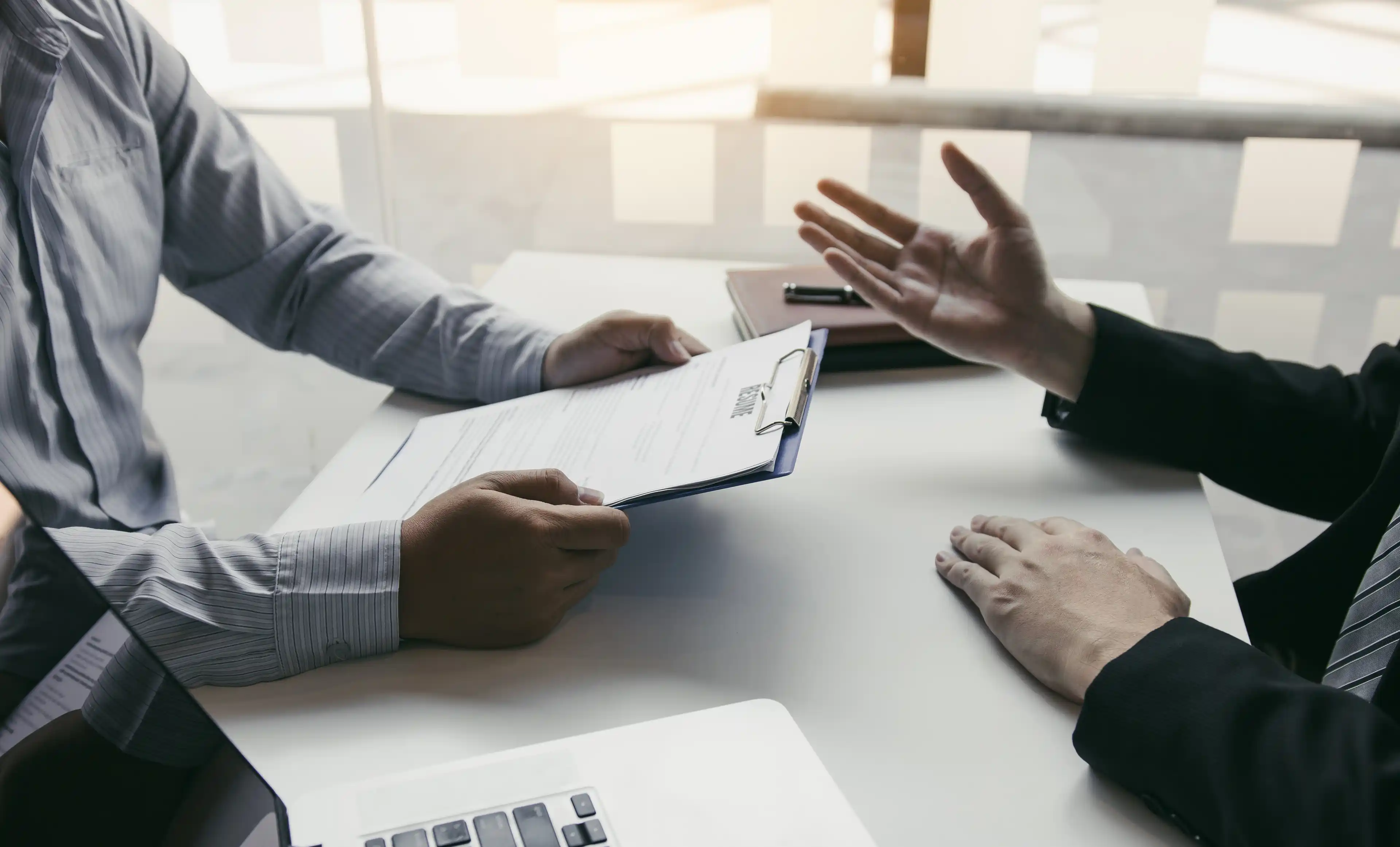 Two people sit across a desk completing a survey