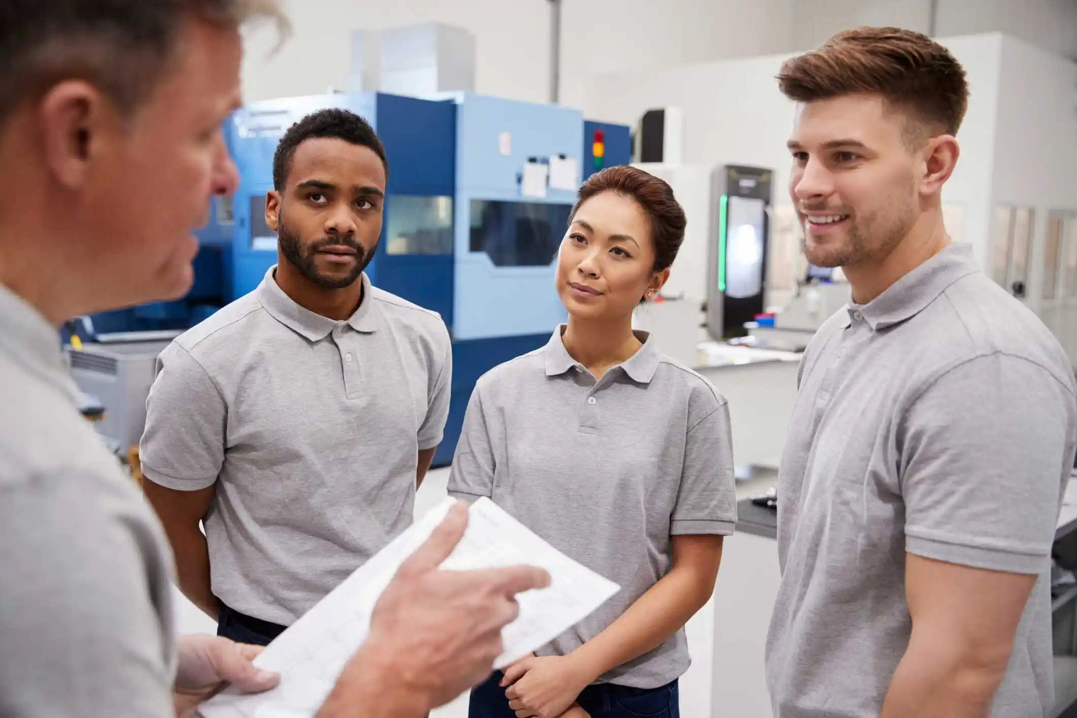 Three students and their instructor standing in a laboratory