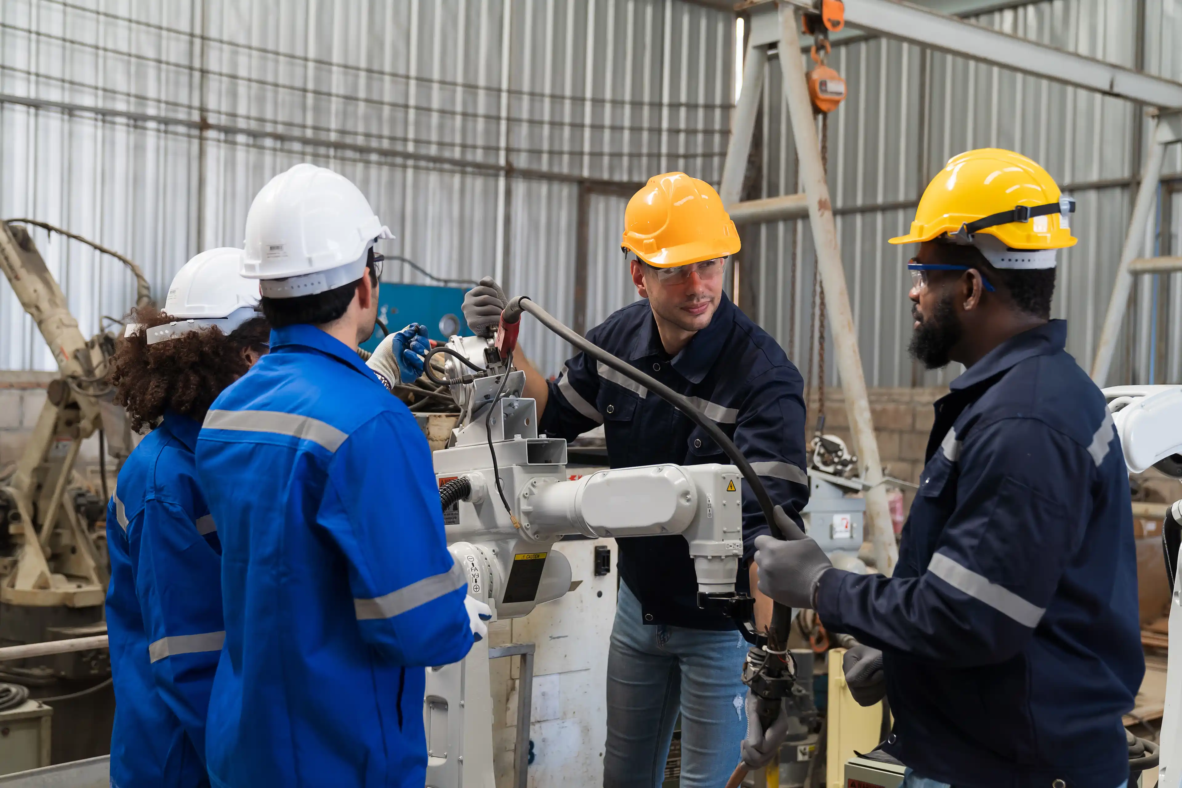 Group of engineer workers discuss and working, checking, repair, maintenance automatic welding robot arm machine at production line in the industry factory stock phot