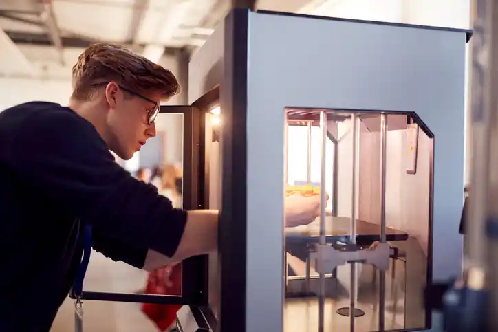An engineer uses a 3D printing machine