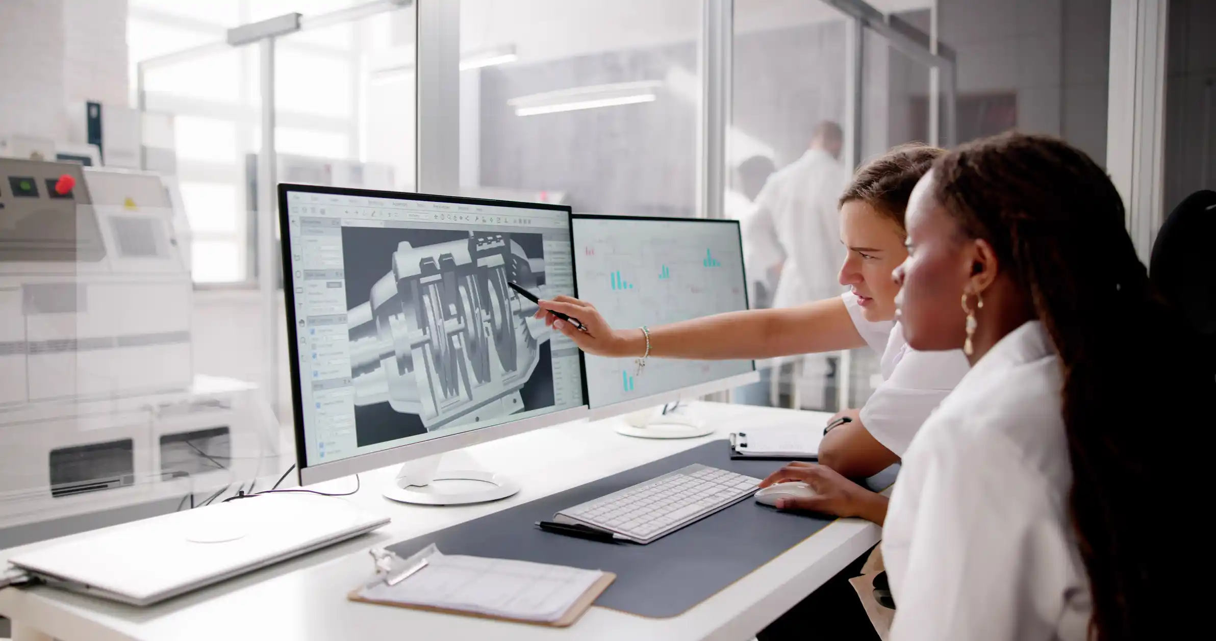 Female engineers in an office, looking at models on computer screens