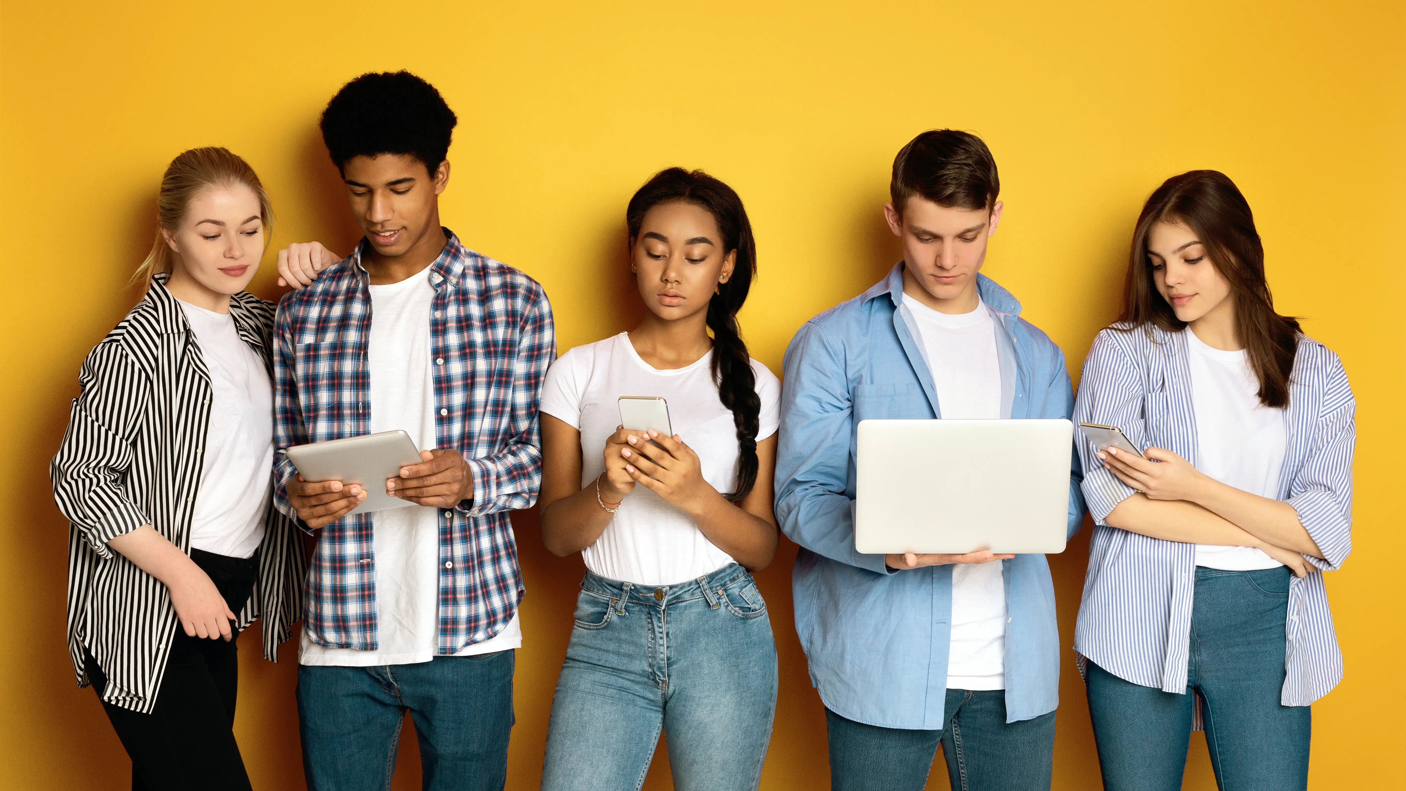 En la fotografía, personas usando diversos dispositivos: laptop, smartphone, tablet, etc.