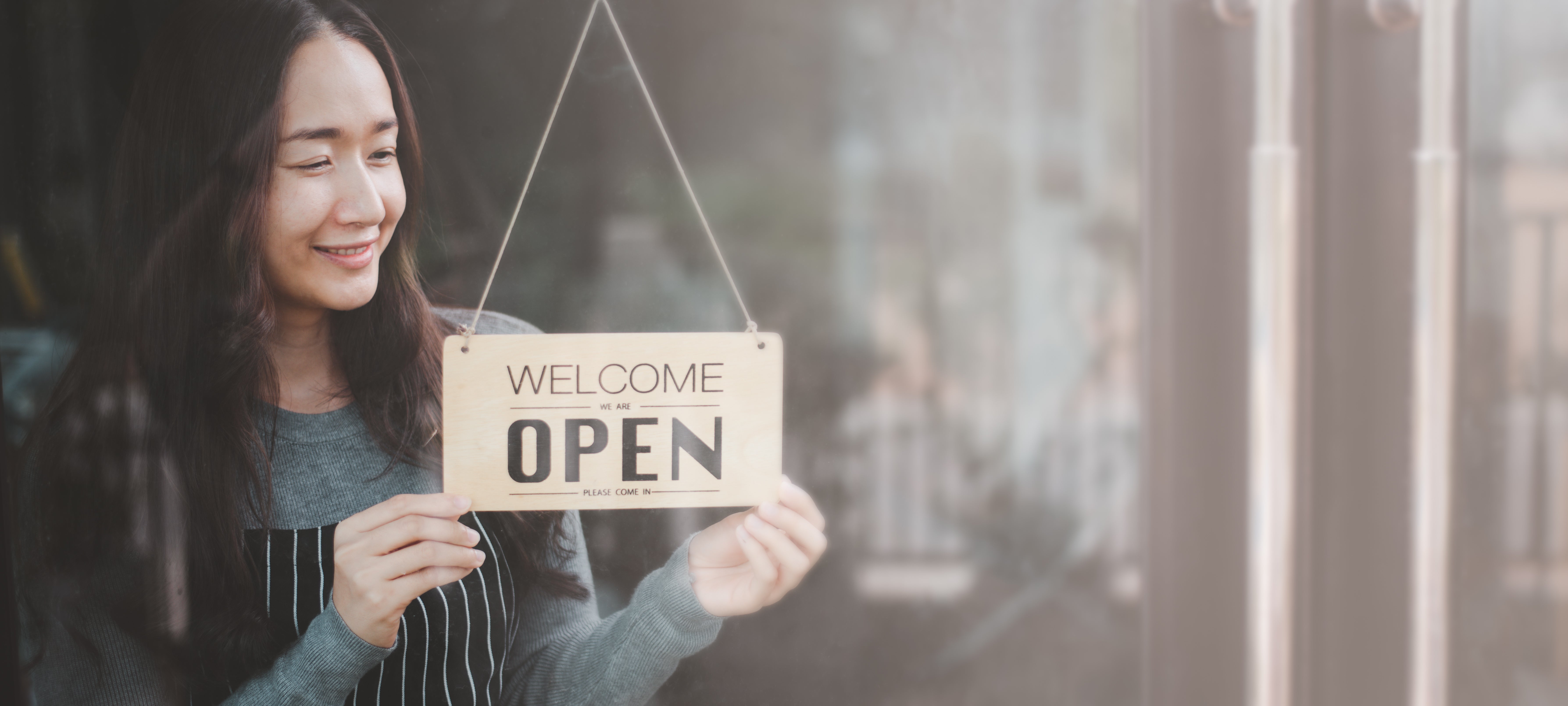 Business owner holds open sign