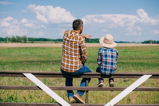 Father and son on fence at their farm