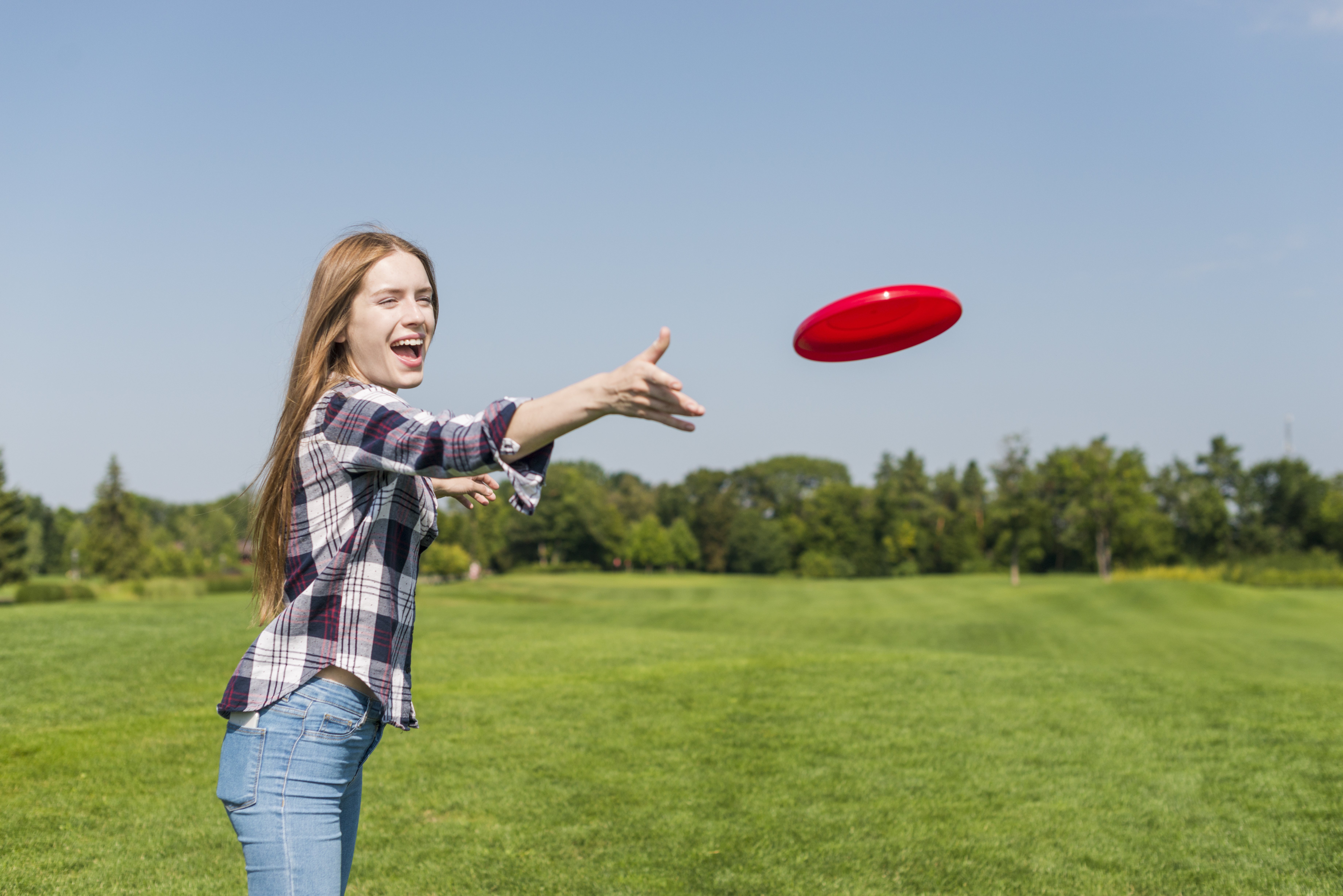 Girl throws frisbee to a friend