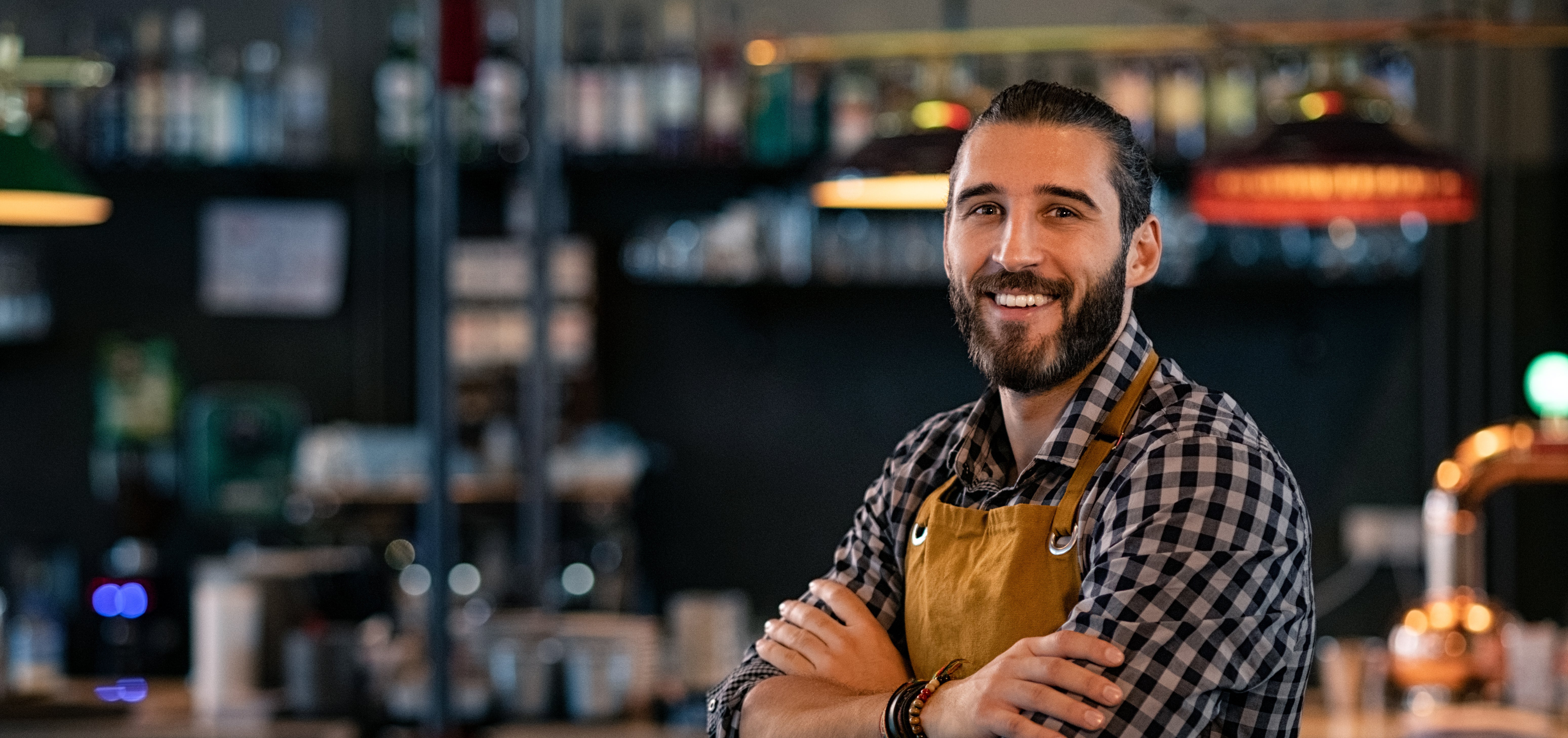 Man smiling in front of a bar