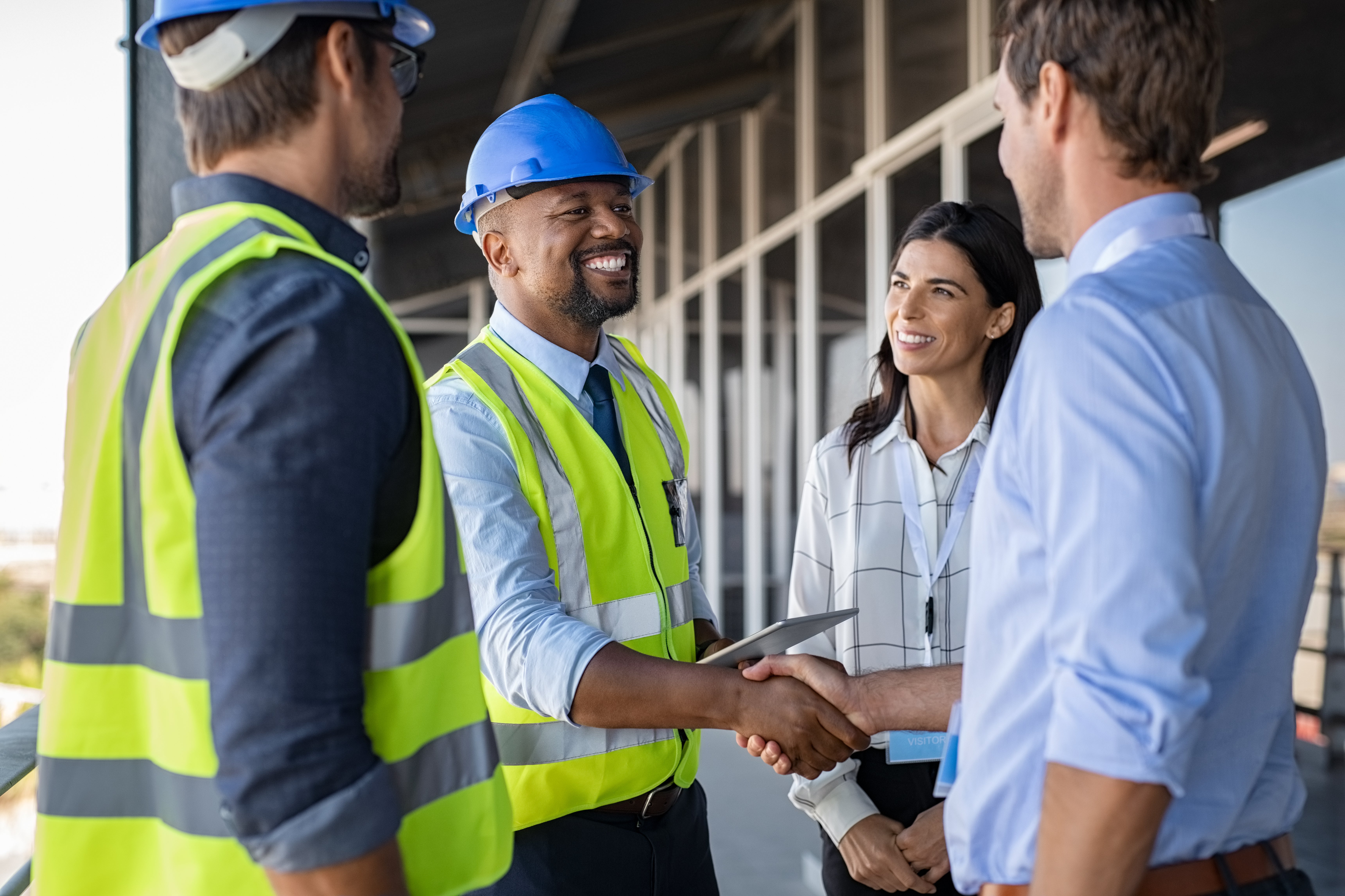 Workers in hard hats shake hands