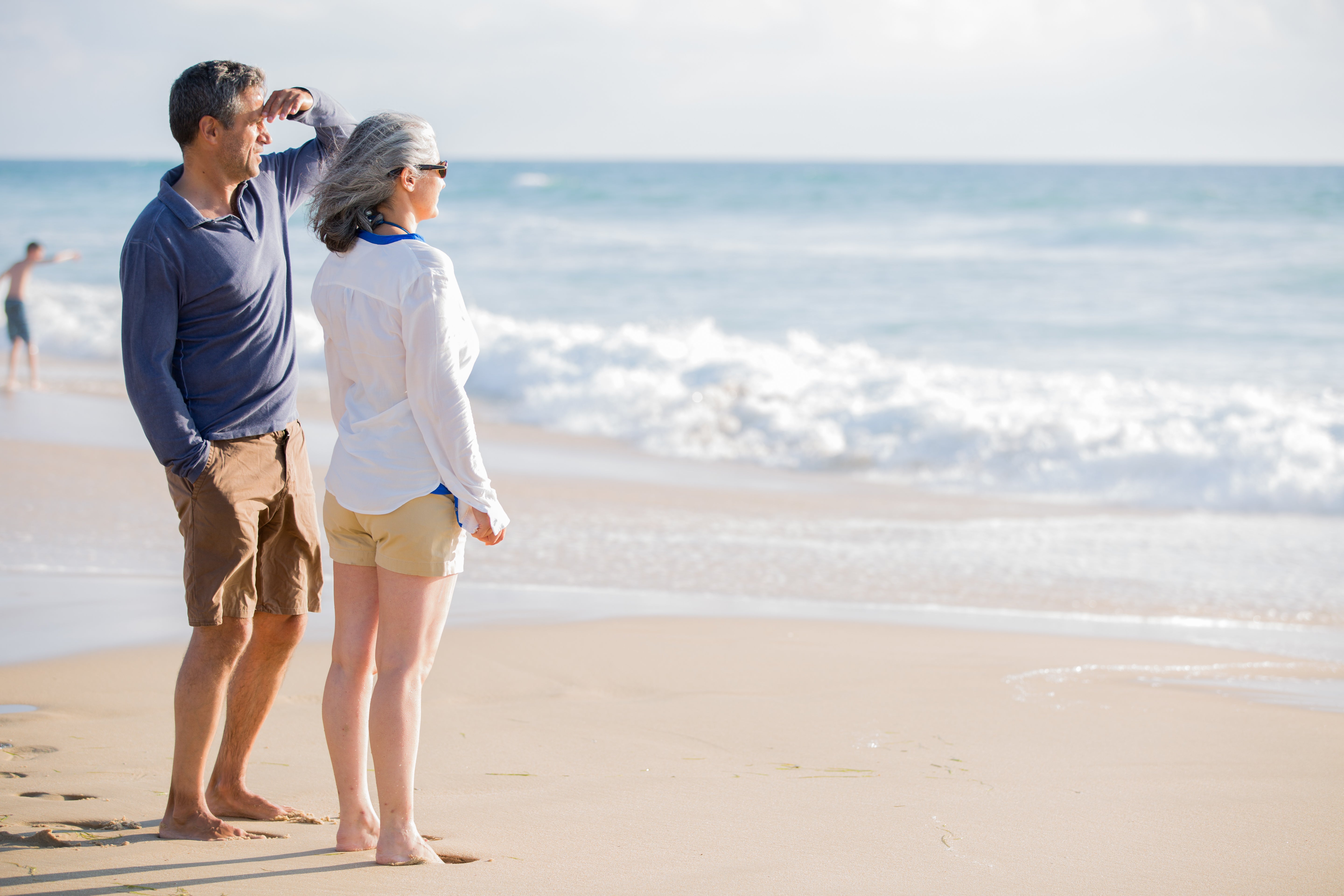 Couple on beach looking at water