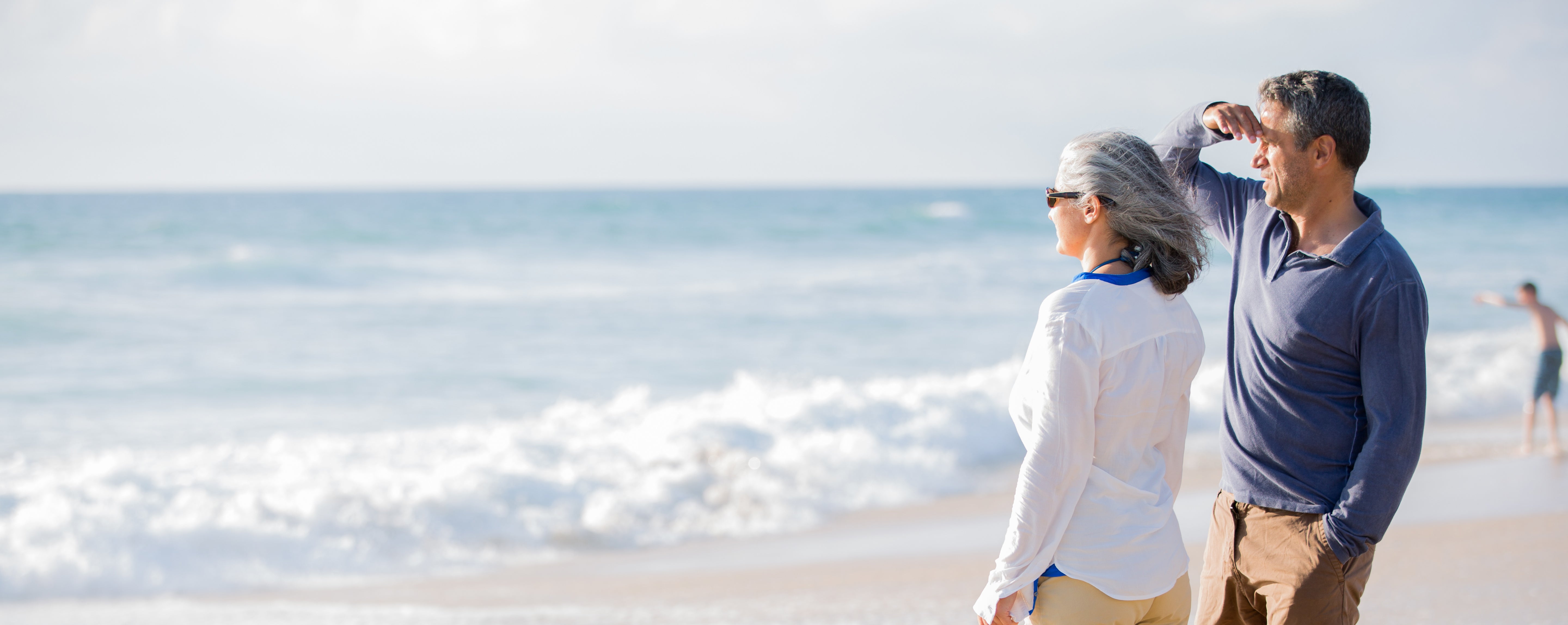 Couple on beach looks at ocean