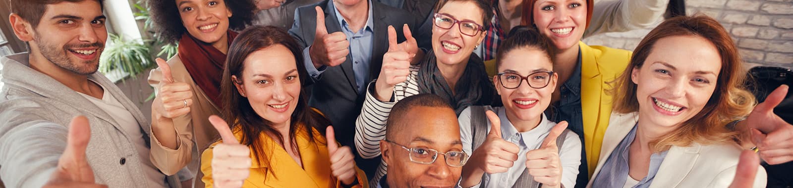 Group of smiling people giving thumbs up