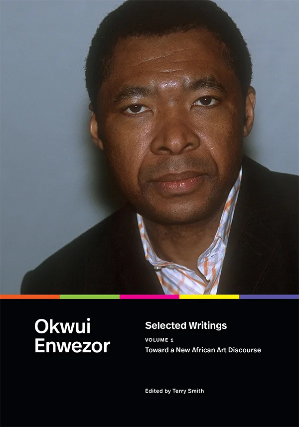 Cover of Toward a Selected Writings, Volume 1 features a close-up photograph of Okwui Enwezor, wearing a dark suit and patterned shirt, with a calm expression.