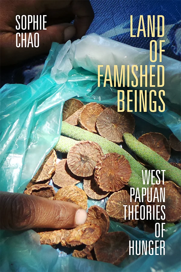 Cover of Land of Famished Beings features a photograph, taken by the author, of dried betel nuts in a plastic bag. The bag also contains what appear to be green pods. A finger belonging to a person with Black skin points at the dried nuts.