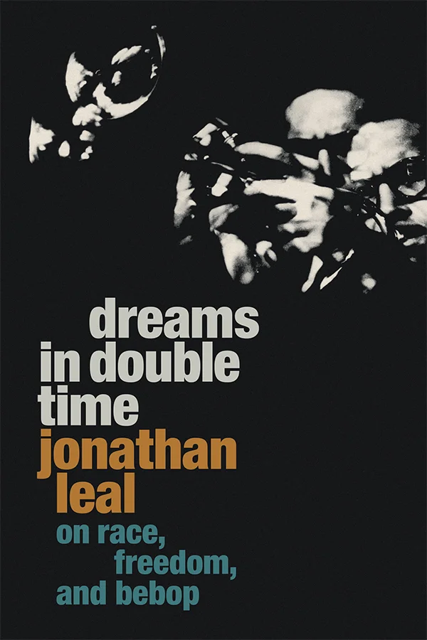 Cover of Dreams in Double Time is a black and white photo of the face and trumpets of two trumpet players. The leftmost wears glasses and the other player stands closely next to him, with his eyes in shadow.