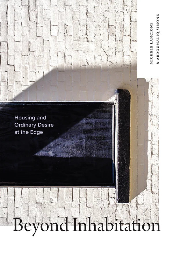 Cover of Beyond Inhabitation shows shadows over a bed frame-like object against a white brick background. The author's names and title are in black serif font. The white subtitle is inside the object.