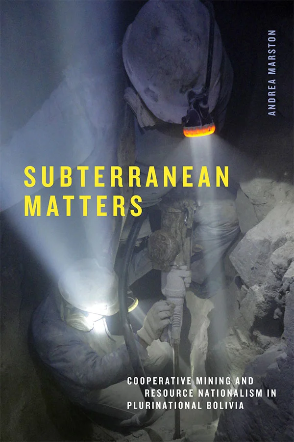 Cover of Subterranean Matters: Cooperative Mining and Resource Nationalism in Plurinational Bolivia by Andrea Marston. Cover features a photograph of two individuals drilling into rock. They wear head lamps and helmets along with long-sleeve shirts and pants, covering every inch of their skin. The individuals also wear gas masks, and the only light sources in the image are their head lamps.