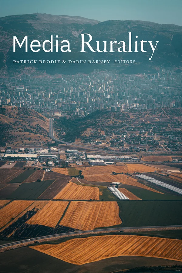 Cover photo on Media Rurality depicts mountains in the far background, behind a city, and winding roads leading to rural fields in the foreground.
