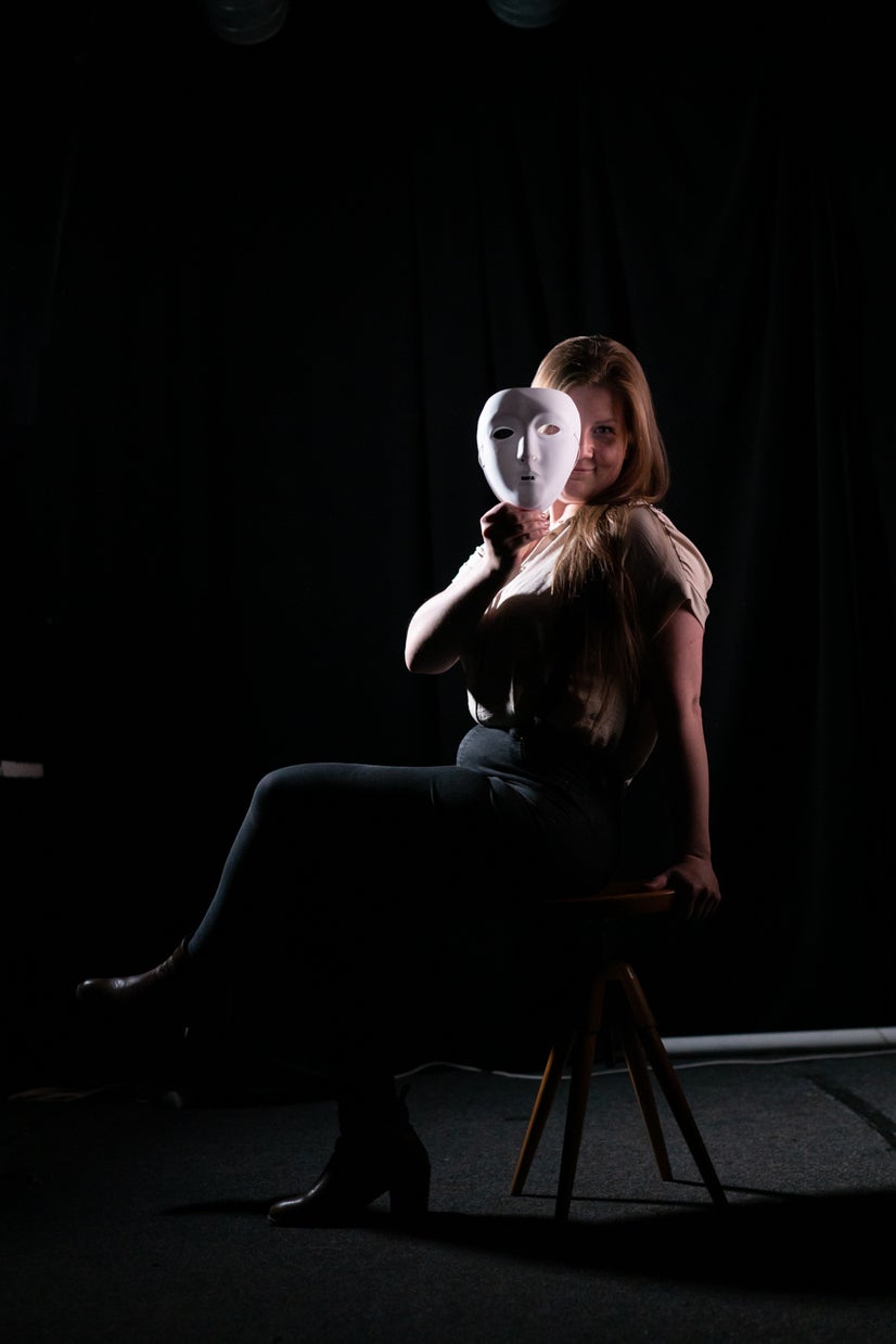 A photo of Marie peeking out from behind a mask.