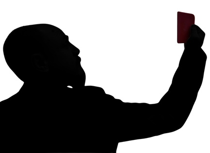 A silhouette of a man with a beard holding a card in his outstretched hand.