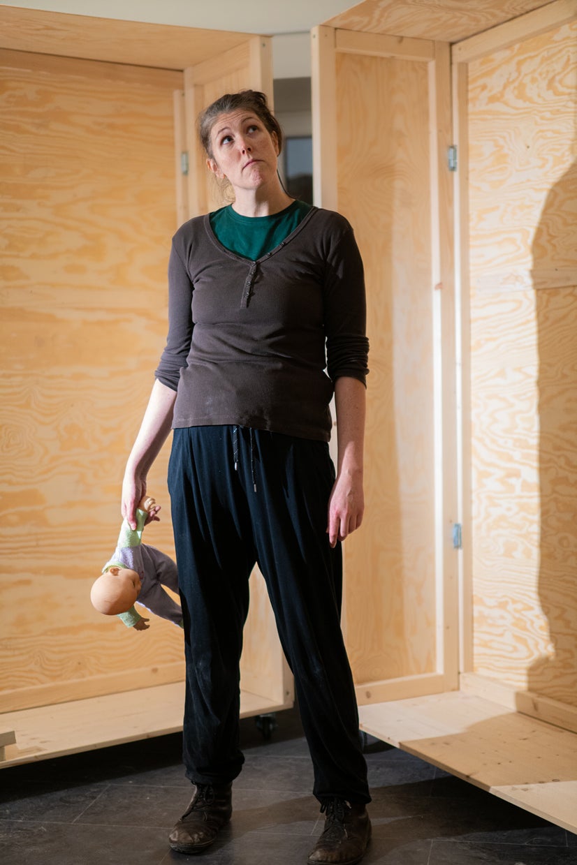 Helena stands alone with her doll.