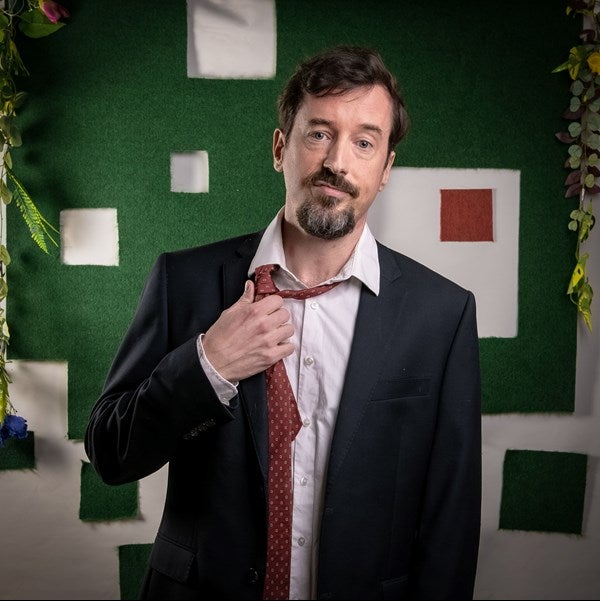 An actor loosens his tie.