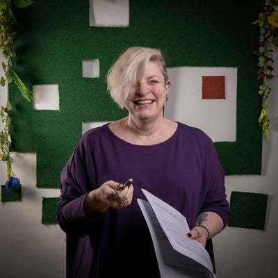 The director laughs with a script in her hand.
