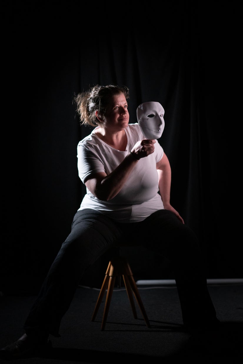 A photo of Jen looking at a mask.