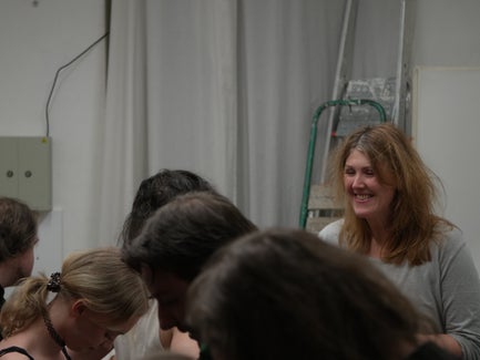 A woman with wild hair smiles backstage.