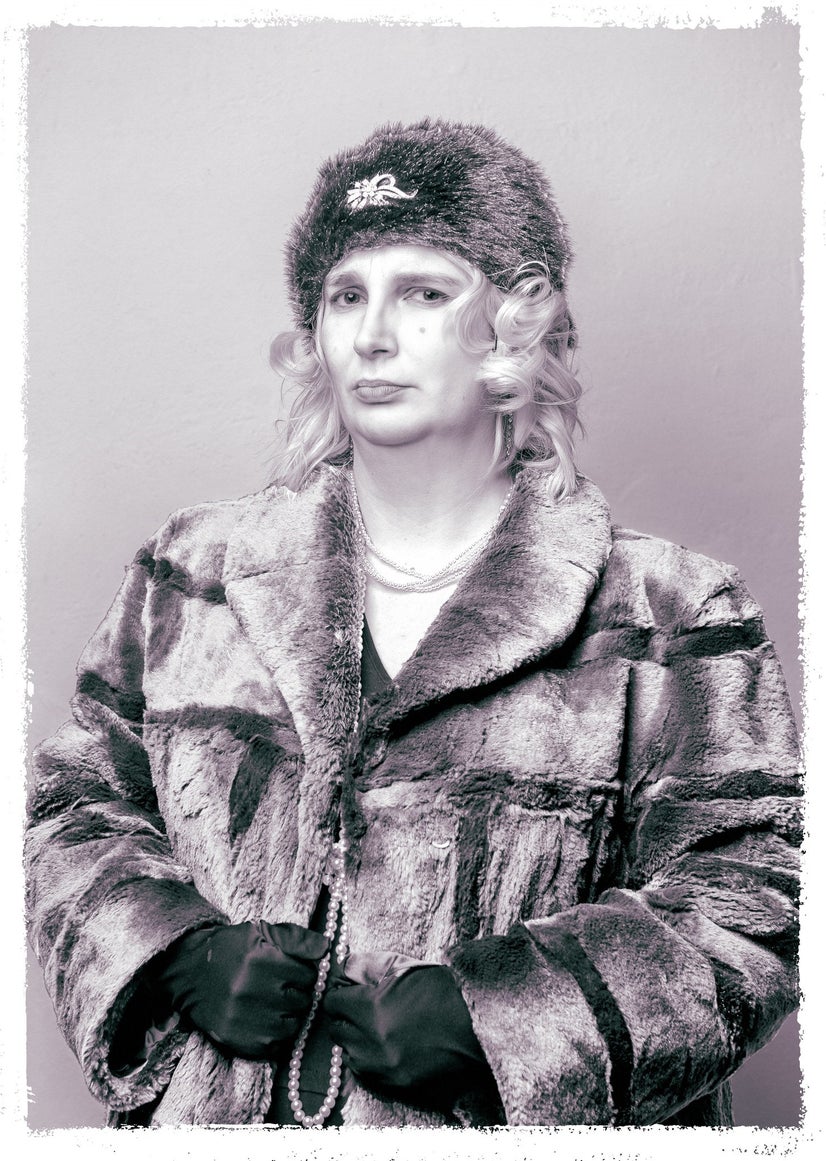 A black-and-white photo of a woman in a fur coat with gloves, strings of pearls, and a fur hat.