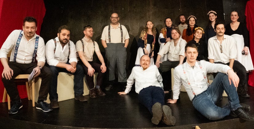 The entire cast spread out across a stage.