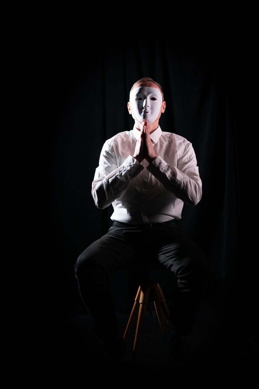 A photo of Frank praying behind a mask.